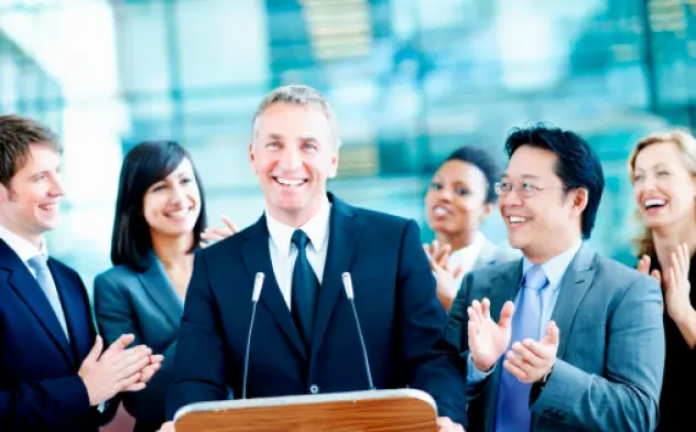 A county Public Relations director finishing off a speech and getting applause from his employees