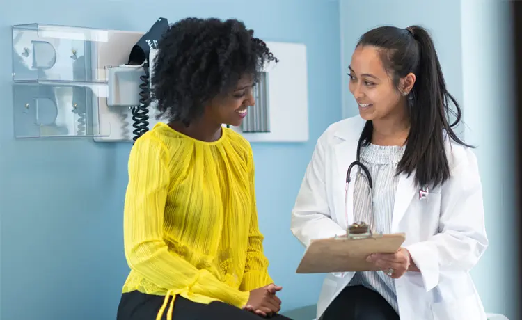 Health Care Benefits For Women Veterans With a Woman being seen by a doctor